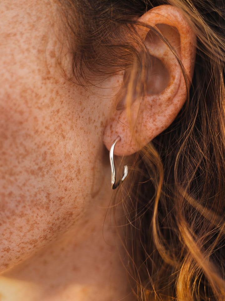 Close-up of an ear with a silver earring.