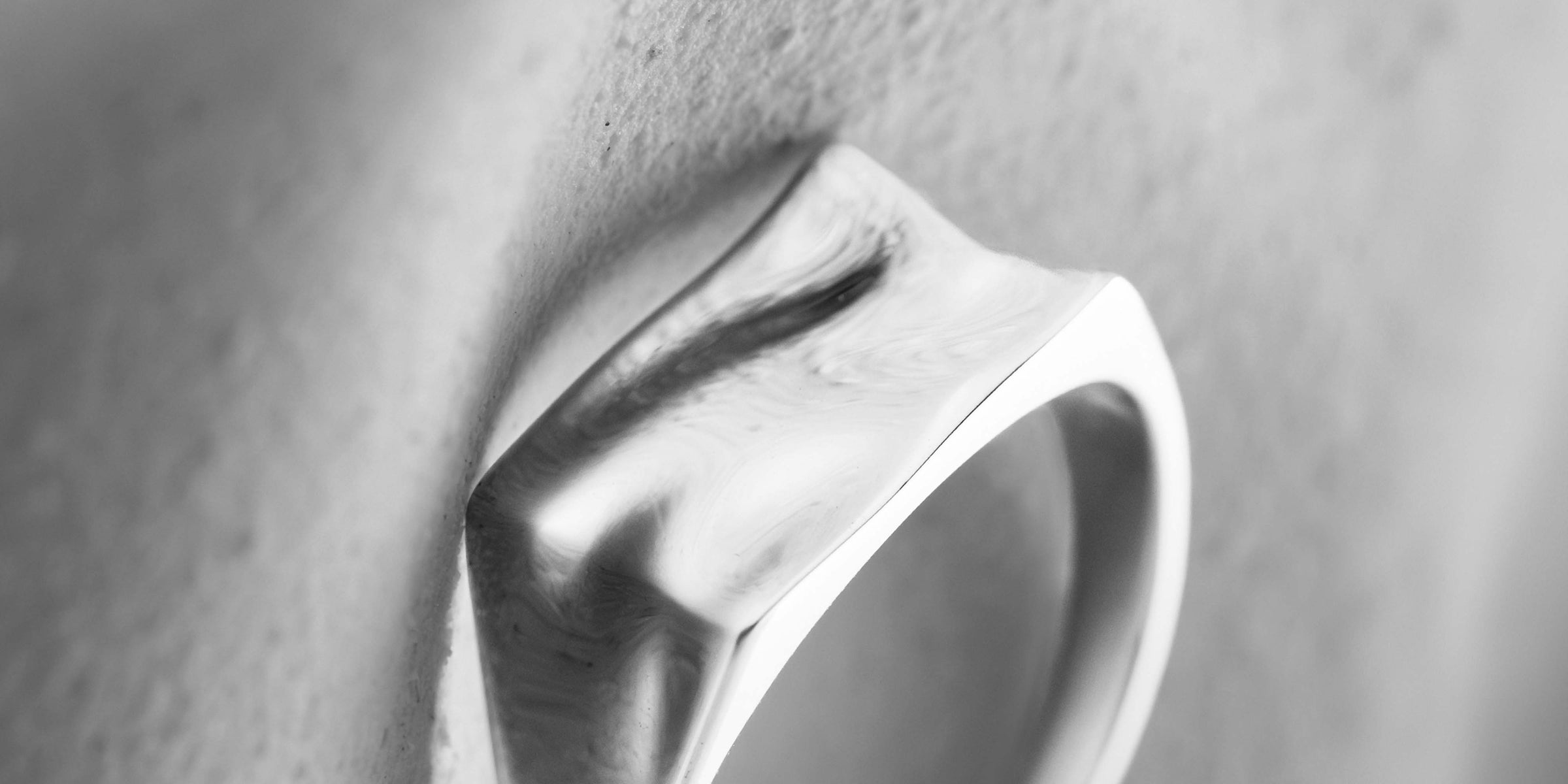 Close-up of a silver ring on a textured surface