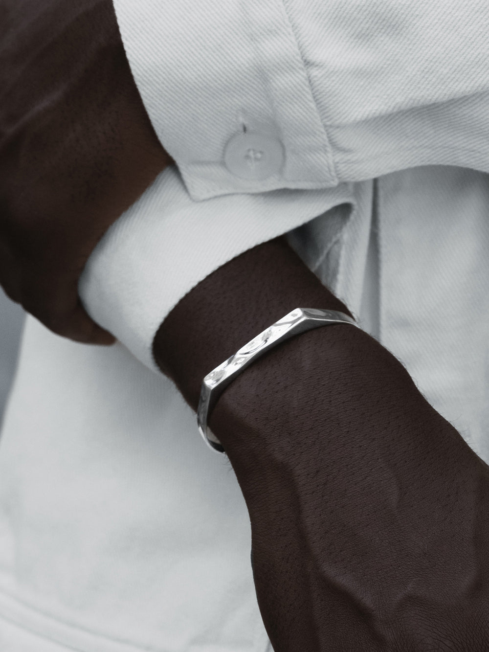 Close-up of a 925 silver cuff on a wrist with a blurred background