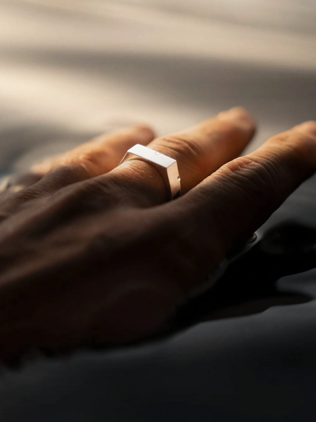 Hand on water surface wearing a silver ring