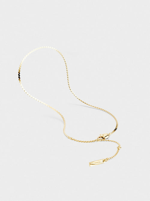 Gold bracelet on a light gray background