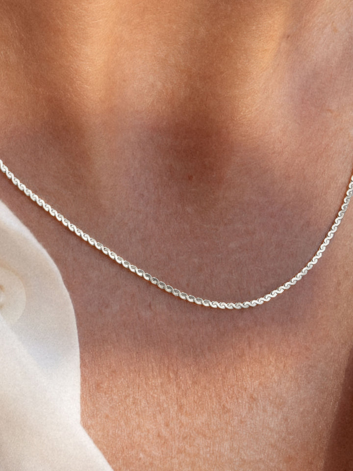 Silver chain necklace on a person's neck